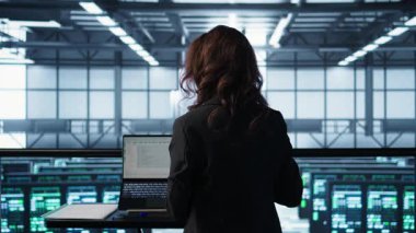 Veri merkezindeki teknisyen güç yönetimi ayarlarını ayarlamak için yapay zeka teknolojisini tablette kullanıyor. Sunucu odasındaki mühendis, yapay zeka ve kamera B kullanarak kaynak kullanımını optimize ediyor