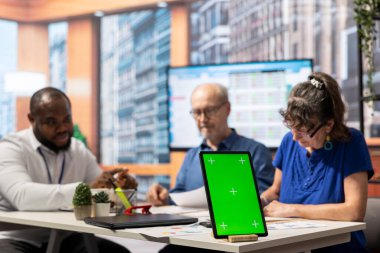 Yaşlı bir adam ve kadın modern ofiste planlamacıyla buluşuyor, dizüstü bilgisayarında izole edilmiş bir model görüntüsü var. Finansal danışman insanların gelirleri için uygun emeklilik planını seçmelerine yardımcı oluyor.