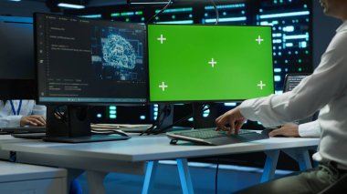 Mühendis sunucu odasında kontrol yapmak için yapay zeka teknolojisini yeşil ekranda kullanıyor. Eğitim için veri tabanlarını işlemek üzere yapay zeka kullanan veri merkezindeki uzmana yakınlaş, kamera A
