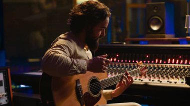 Genç sanatçı söz yazarı, stüdyo kaydında gitarda yeni bir şarkı besteleyerek, daha sonra prodüksiyondan sonra besteleme ve besteleme yapıyor. Şarkılar besteleyen müzisyen. Kamera A.