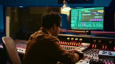 Elektronik klavyede yetenekli müzisyen kayıt melodileri, piyanoda şarkı söylemek ve stüdyoda ses mühendisiyle müzik yaratmak. Genç sanatçı besteci konsolda şarkıları düzenliyor. Kamera B.