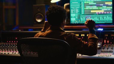 Afrika kökenli Amerikalı ses mühendisi konsolu karıştırma ve müzik endüstrisi sonrası prodüksiyon üzerine kaydettiği şarkıdan memnun. Ses teknisyeni kontrol odasında hit bir şarkı yapıyor. Kamera A.
