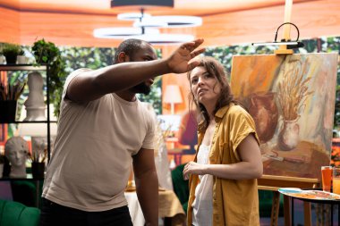 Erkek ressam, yeni bir sanat eserini resmetmeden önce vizyon ve fikirlerini paylaşıyor ve bu süreci ve tekniği atölyedeki meslektaşına anlatıyor. Atölyede çeşitli sanatçılar çalışıyor.