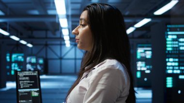 Veri merkezinde bilgisayar klavyesinde yazan programcı, sistemin ağ görevlerini yerine getirmesini sağlıyor. Bilgisayar, kamera B ile ağ trafiğini takip eden sunucu çiftliği bilişim uzmanı