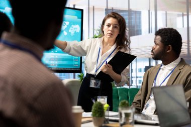 Şirket ortakları konferans odasında proje detayları ve zaman çizelgelerini inceliyor, rekabetçi bir iş ortamında hedeflere ulaşmak için bütçe ve operasyonlar kuruyor.