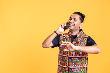 Komik bir adamla telefonda muhabbet etmek, eğlenmek. Geleneksel Hint kıyafeti giyen mutlu insan gülüyor, telefon görüşmesinde bir arkadaştan espriler duyuyor, stüdyo geçmişi var.