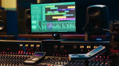 Müzik kayıt endüstrisinde kullanılan boş kontrol odası profesyonel stüdyo, konsolu karıştırma ve prodüksiyon ekipmanları. Daw yazılımı, solgunlaştırıcıları ve ses düzenleme araçlarıyla ses geçirmez alan.