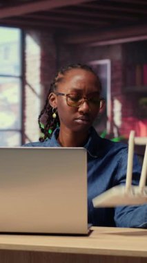 Afrikalı Amerikalı bir kadın kablo çekerek internet sağlayıcısından destek alarak kablosuz internet modemini yeniden başlatıyor. Devam eden Wi-Fi bağlantı sorunları. Kamera B.