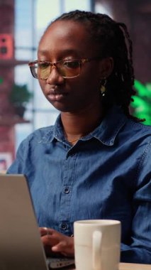 Afrika kökenli Amerikalı bir kadın partneriyle görevleri çözmek için not defterinde raporları kontrol ediyor, evlerinin rahatlığından bağımsız işler yapıyor. Bilgisayarla araştırma yapan odaklanmış insanlar. Kamera B.