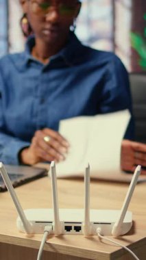 Evde zayıf internet bağlantısıyla boğuşan, LAN kablosunu çıkaran ve sinyali geri getirmek için Wi-Fi ayarlarını ayarlayan genç bir kadın. Teknik sorunları olan serbest çalışan bir kadın. Kamera A.