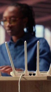 Evde zayıf internet bağlantısıyla boğuşan, LAN kablosunu çıkaran ve sinyali geri getirmek için Wi-Fi ayarlarını ayarlayan genç bir kadın. Teknik sorunları olan serbest çalışan bir kadın. Kamera B.