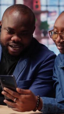 Afrika kökenli Amerikalı erkek ve kadın masada oturmuş serbest stratejileri tartışıyor, yararlı bir rapor oluşturmak için telefon pazarlama eğilimlerini araştırıyorlar. Takım çalışması yapan bir çift. Kamera B.