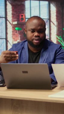 Evlerindeki Afrikalı Amerikalılar hesap aboneliğini yenilemek ve dizüstü bilgisayardaki yayın hizmetlerini yönetmek için kart numaralarını giriyorlar. Çift para aktarıyor, kimlik bilgilerini güncelliyor. Kamera A.