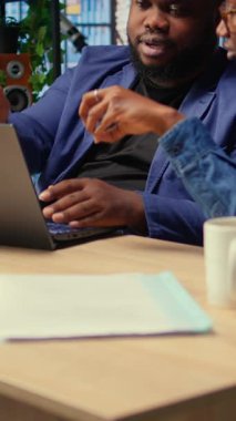 Genç çift masa başında takım çalışması ve çoklu görev yapıyor, serbest çalışma ve uzak sorumlulukları yönetirken internete tamamen bağlı. Evde web taraması. Kamera A.