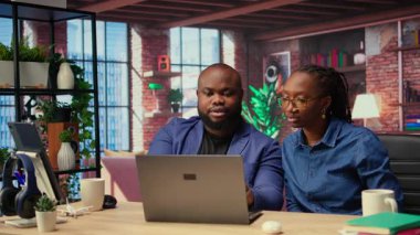 Siyahi serbest çalışan çift başarılarını kutlamak için beşlik çakıyor ve başarılı bir proje için görevlerini tamamlıyorlar. Genç adam ve kadın iş birliklerinden memnunlar. Kamera A.