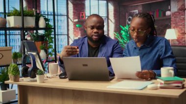 Evlerindeki Afrikalı Amerikalılar hesap aboneliğini yenilemek ve dizüstü bilgisayardaki yayın hizmetlerini yönetmek için kart numaralarını giriyorlar. Çift para aktarıyor, kimlik bilgilerini güncelliyor. Kamera A.