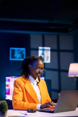 Evdeki kişi dizüstü bilgisayarda internette geziniyor, çevrimiçi bilgi araştırıyor, web sitelerine giriyor, makaleleri okuyor, belgeleri indiriyor, çalışma görevleriyle ilgili veri bulmak için arama motorlarını kullanıyor