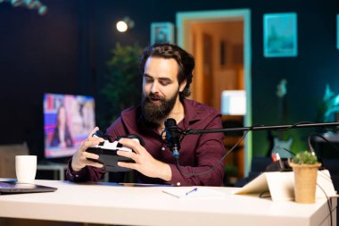 RGB ışıkları oturma odasındaki VR gözlüklerini inceleyen bir teknisyen. Profesyonel kamera ve mikrofon kullanan alet meraklıları için içerik oluşturucu teknoloji kanalı vlog 'u eğlenceli