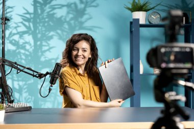 Film stüdyosundaki mutlu kadın teknoloji meraklıları için gösterişli bir video eleştirisi sunuyor. Neşeli internet yıldızı internet şovu sunuyor, kutuları açıyor, incelikten etkileniyor.