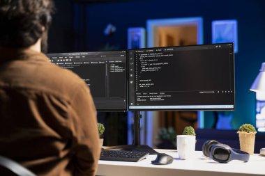 Şirket sistemlerini ve verilerini korumak için güvenlik önlemleri uygulayan bir adam. Yazılım uygulamaları için teknik destek yazma, test etme ve hata ayıklama kodu