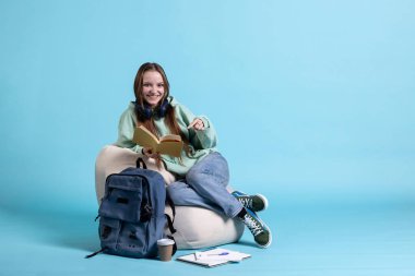 Kitap okurken gülümseyen, hobiden zevk alan, eğlenen, stüdyo geçmişi olan heyecanlı genç bir kızın portresi. Kollarında tuhaf sırıtan neşeli bir kadın, entrikayla eğleniyor.