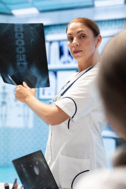 Doktor, bir toplantıda meslektaşlarına röntgen taraması sonuçlarını gösteriyor. Tanıya dayalı tedavi seçenekleri üzerinde uzmanlaşmış kişiler. Radyografi ile hastalıkları önleme stratejileri.