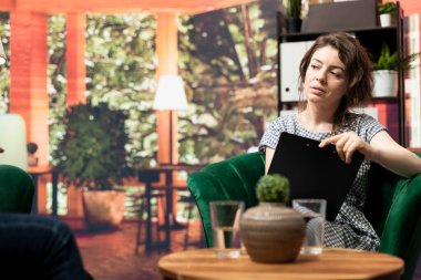 Psikoloji uzmanı terapi toplantısında bir müşterinin gelişimini yazıyor. Anksiyete ve depresyonun üstesinden gelmek için danışmanlık öneriyor. Ruh sağlığı sorunlarına bakan danışman.