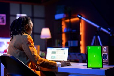 Bilgisayardaki hesap tabletlerini tamamlayan uzaktan kumandalı çalışanın yanındaki yeşil ekran model tableti. Chroma anahtar izole ekran aygıtı ofis çalışanının yanında defter üzerinde belge düzenleme