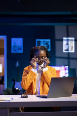 Yorgun genel Z tele-çalışanı iş üzerinde çalışırken defter ekranına çok fazla bakmaktan gözünün yorulduğunu hissediyor. Yorgun serbest çalışan biri, evde çalışırken rahatlamak için gözlük takıyor.