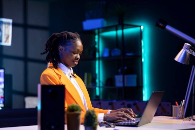 Ofiste masa başında oturan ve dizüstü bilgisayarda klavye çalan serbest çalışan biri. İnternet üzerinden müşteri ilişkileri işi yapmak için elektronik aygıt kullanan uzak bir çalışan, sorulara yanıt veriyor