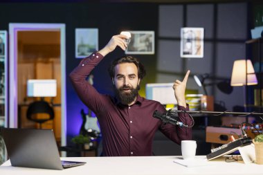 İçerik yaratıcısı fikri göstermek için ampul kullanıyor. Seyirciye söyleyecek parlak bir sezgisi var. Apartman dairesinde film çekerken ilham konseptini göstermek için parmakla gösterici