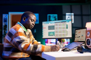 Finansal danışman, küresel yatırımlarda geliri riske atmadan önce CEO için yeni bir rapor oluşturmaya çalışarak yıllık istatistiklerle gelir dengesi üzerinde çalışıyor. Erkek muhasebeci yasal sigortayı değerlendiriyor..