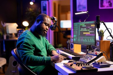 Şarkıları için yeni sözler besteleyen yetenekli bir sanatçı ve stüdyosundaki ses cihazlarıyla müzik kaydediyor. Şarkıcı besteci notalar alarak ve kafiyeler ya da şarkılar oluşturarak melodik materyal yazar..