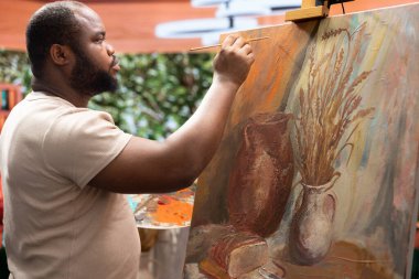 Ressam, bir tuvale belli bir teknikle suluboya boya boya uygular ve çarpıcı bir sanat eseri yaratır. Sanatçı boş zamanlarında canlı renkler ve dinamik fırça darbeleri kullanır..