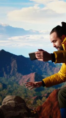 Dikey Video Aptal Yürüyüşçü dikkatsiz davranıp akıllı telefonu düşürüyor ve dengesini kaybediyor. Sert dağ ortamı için donanımsız biri. Doğada teknolojik bir takıntı ile yürüyüş riskleri