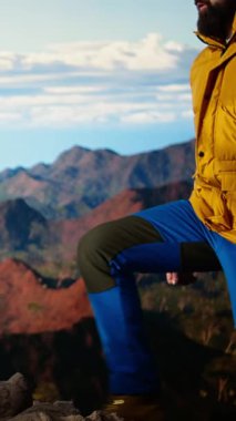 Dikey Videolu Kararlı Yürüyüşçü, gökyüzünün enginliği ve engebeli zirvelerden esinlenerek destansı dağ sırasına ve manzarasına bakıyor. Açık havayı kucaklamanın mükafatı. Kamera A.