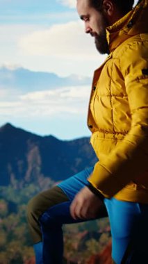 Dikey Video Kararlı Dağcı, dağlarla manzaranın ve engin gökyüzünün hayranlık uyandırıcı bir zemin oluşturması için duraksadı. Keşif ve macera için doğa yürüyüşü yapan bir adam. Kamera A.