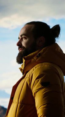 Dikey Video Yürüyüşçüsü vahşi doğada yürümenin zorluğunu kucaklıyor, panoramik dağ manzarasından güç ve açık hava macerasının ödülü olarak zevk alıyor. Macera Avcısı