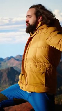 Dikey Video Maceracısı başarılı bir tırmanışın hazzıyla zirvede duruyor, gururlu ve dağın tepesindeki sert rüzgarın tadını çıkarıyor. Özgürlüğü ve doğayı sevmek. Kamera B.