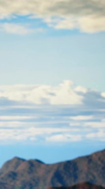 Dikey Görüntü Yalnız Gezgini dağın zirvesinde dikiliyor. Sersemletici tepe manzarası, bulutlar ve sonsuz gökyüzü, maceraperest. Nefes kesici manzara kararlılığı sembolize eder. Kamera B.