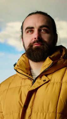 Sıcak kıyafetler içinde dikey video maceraperestleri vahşi doğanın huzurunu, panoramik dağ manzarasını ve açık gökyüzünün rahatlama için mükemmel bir ortam yaratmasını severler. Soğuk rüzgarlar yokuş yukarı. Kamera B.