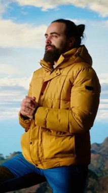 Dikey Video Gezgini yüksek rakımlı yabanda tek başına duruyor nefes kesici manzaraya hayran kalıyor, temiz havanın ve çarpıcı dağ manzarasının tadını çıkarıyor. Huzurlu atmosfer farkındalığa ilham verir.