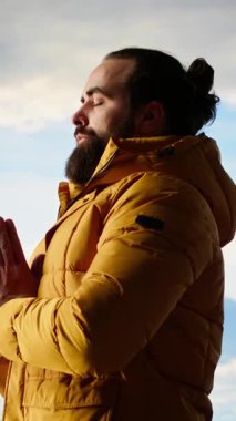 Dikey Video Genç kaşifi dağın zirvesine ulaşıyor ve en tepede meditasyon yapıyor, sakin ve dikkatli bir şekilde zen meditasyonu yapıyor. Keyifli yürüyüşçüler doğayı özen gösterdikleri için severler. Kamera B.
