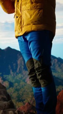 Dikey video, sakin doğa aşığını memnun eder dağ sırasının tepesinde meditasyon yapar, meditasyon yapar ve zihinsel berraklık ve refah için derin nefesler alır. Huzurlu zen yürüyüşçüsü tırmanmayı sever