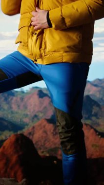 Dikey Video Dağı yürüyüşçüsü, zirveye tırmandıktan sonra ceketinin fermuarını çekerek geniş bir tepe ve gökyüzü manzarasıyla vahşi doğada yolculuk macerasını kucaklıyor. Açık hava keşfi