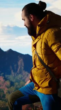 Dikey Görüntü Fotoğrafçısı, insansız hava aracıyla dağın tepesinde profesyonel içerik kaydediyor, yabanda yürüyüş yapıyor ve manzaralı bir manzara görüntüsü yakalıyor. Vahşi doğanın hava fotoğrafçılığı. Kamera A.