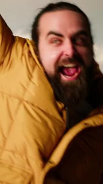 Dikey Videocu, nefes kesici bir dağ zirvesinde manzaranın keyfini çıkararak, başarılı bir yürüyüşten sonra mutlu ve tatmin edici bir şekilde kutluyor. Gururlu yürüyüşçü kararlılığı somutlaştırır