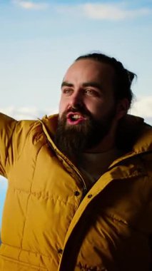 Dikey Video Maceracısı nefes kesen bir manzara için yüksek bir dağın tepesinde duruyor. Yürüyüşçülerin kollarını kaldırmasından ve sevinçten çığlık atmasından memnun. Korkuları ve zorlukları yenmek. Kamera B.