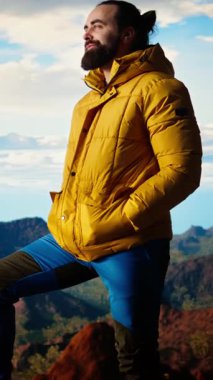 Sıcak kıyafetler içinde dikey video maceraperestleri vahşi doğanın huzurunu, panoramik dağ manzarasını ve açık gökyüzünün rahatlama için mükemmel bir ortam yaratmasını severler. Soğuk rüzgarlar yokuş yukarı. Kamera A.