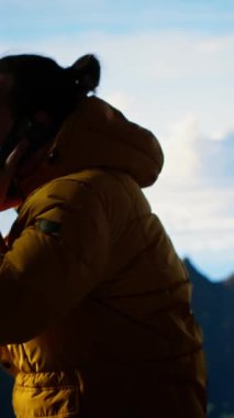 Dikey Video Trekker yüksek rakımlı manzaradan zevk alır ve bir telefon görüşmesi yapar, panoramik dağ manzarası ve gevşek hava rahatlama için mükemmel bir manzara sağlar. Onun üzerinde güçlü bir sinyal kullanıyor.